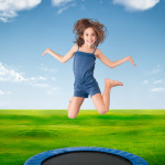 cheerful girl jumping on a meadow