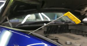 Technik vykonávajúci opravu preliačiny na aute metódou PDR bez potreby lakovania.