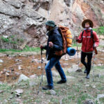 Turista s výbavou na jarnú túru v horách vrátane batohu a oblečenia