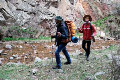 Turista s výbavou na jarnú túru v horách vrátane batohu a oblečenia