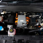 Automechanik vykonáva diagnostiku elektronických systémov automobilu pomocou diagnostického zariadenia pripojeného k vozidlu.